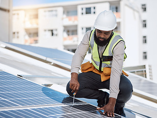 Image showing African engineer man, screwdriver and solar panel on roof for maintenance, industry or thinking in city. Technician, builder and tools for photovoltaic tech, helmet and sustainable renewable energy