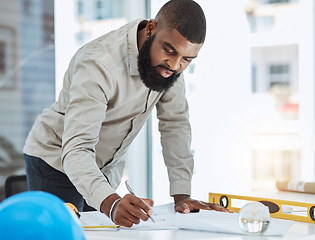 Image showing Architect, blueprint and black man writing in office on paper, construction and project planning. Engineer, architecture and male manager with plan for property and renovation strategy with focus