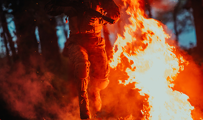 Image showing Soldier in Action at Night in the Forest Area. Night Time Military Mission jumping over fire