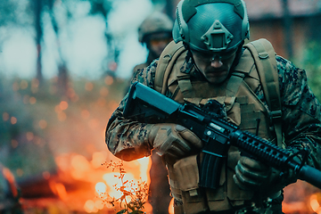 Image showing Soldier in Action at Night in the Forest Area. Night Time Military Mission jumping over fire