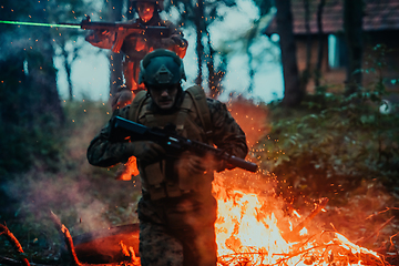 Image showing Soldier in Action at Night in the Forest Area. Night Time Military Mission jumping over fire