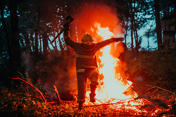 Image showing firefighter hero in action danger jumping over fire flame to rescue and save