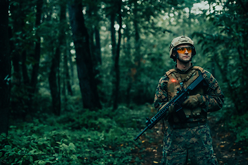 Image showing A soldier fights in a warforest area surrounded by fire