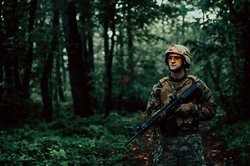 Image showing A modern warfare soldier on war duty in dense and dangerous forest areas. Dangerous military rescue operations