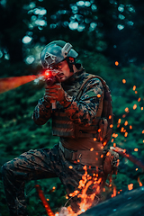 Image showing A soldier fights in a warforest area surrounded by fire