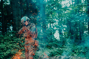 Image showing A soldier fights in a warforest area surrounded by fire