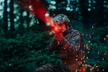 Image showing A soldier fights in a warforest area surrounded by fire