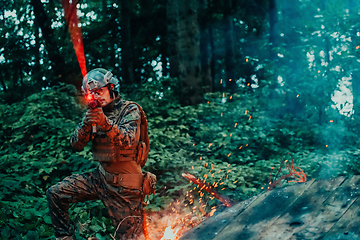 Image showing A soldier fights in a warforest area surrounded by fire