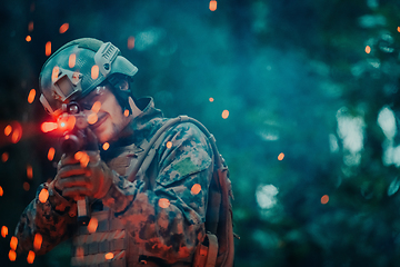 Image showing A soldier fights in a warforest area surrounded by fire