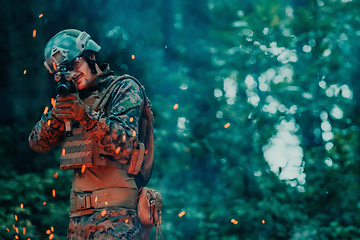 Image showing A soldier fights in a warforest area surrounded by fire