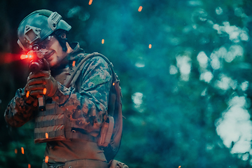 Image showing A soldier fights in a warforest area surrounded by fire