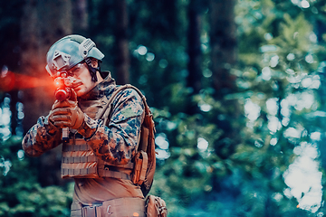 Image showing A soldier fights in a warforest area surrounded by fire