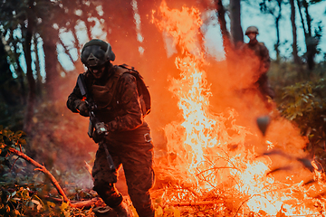 Image showing Soldier in Action at Night in the Forest Area. Night Time Military Mission jumping over fire