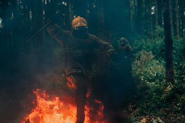 Image showing firefighter hero in action danger jumping over fire flame to rescue and save