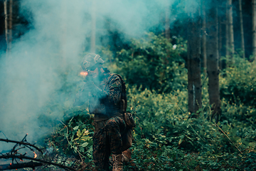 Image showing A soldier fights in a warforest area surrounded by fire