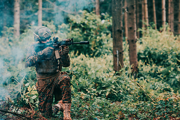 Image showing A soldier fights in a warforest area surrounded by fire