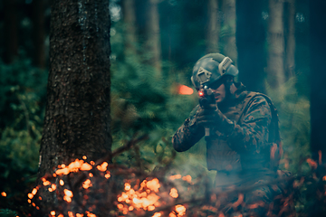 Image showing A soldier fights in a warforest area surrounded by fire