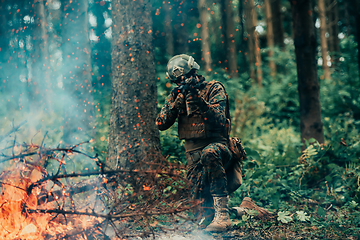 Image showing A soldier fights in a warforest area surrounded by fire