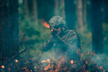 Image showing A soldier fights in a warforest area surrounded by fire