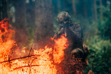 Image showing A soldier fights in a warforest area surrounded by fire