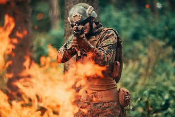 Image showing A soldier fights in a warforest area surrounded by fire