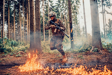 Image showing Modern warfare soldier surrounded by fire, fight in dense and dangerous forest areas