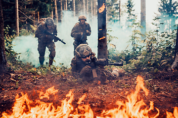 Image showing Modern warfare soldiers surrounded by fire fight in dense and dangerous forest areas