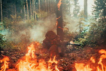 Image showing Modern warfare soldier surrounded by fire, fight in dense and dangerous forest areas