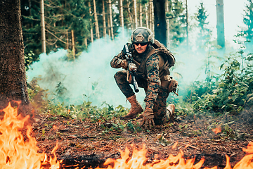 Image showing Modern warfare soldier surrounded by fire, fight in dense and dangerous forest areas