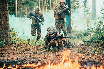 Image showing Modern warfare soldiers surrounded by fire fight in dense and dangerous forest areas