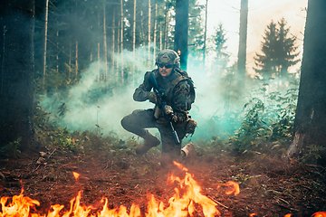 Image showing Modern warfare soldier surrounded by fire, fight in dense and dangerous forest areas