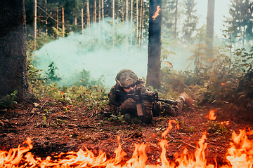 Image showing Modern warfare soldier surrounded by fire, fight in dense and dangerous forest areas