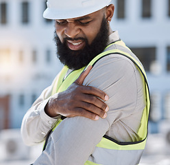 Image showing Injury, arm pain and a black man construction worker on a building site, feeling fatigue in his shoulder. Burnout, emergency or accident and a male engineer holding his muscle with inflammation