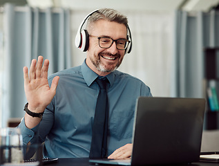 Image showing Headphones, laptop and man wave on video call for business, smile and online chat at home. Happy, hello and webinar of mature manager with glasses in virtual meeting, communication and remote work