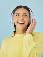 Image showing Woman with smile, headphones and mockup in studio for podcast, mobile app and streaming radio site. Sound, music subscription and happy girl listening to audio on earphones on blue background space.