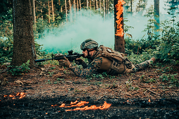 Image showing Modern warfare soldier surrounded by fire, fight in dense and dangerous forest areas