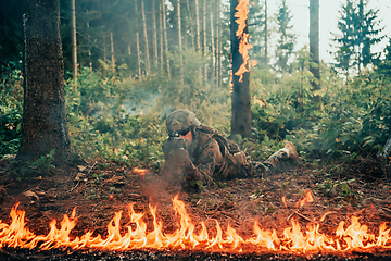 Image showing Modern warfare soldier surrounded by fire, fight in dense and dangerous forest areas