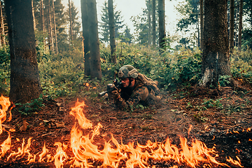 Image showing Modern warfare soldier surrounded by fire, fight in dense and dangerous forest areas