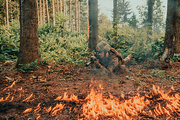 Image showing Modern warfare soldier surrounded by fire, fight in dense and dangerous forest areas