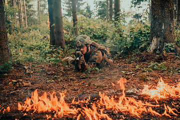 Image showing Modern warfare soldier surrounded by fire, fight in dense and dangerous forest areas