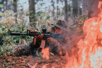 Image showing A soldier fights in a warforest area surrounded by fire