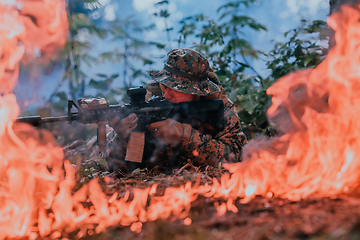 Image showing A soldier fights in a warforest area surrounded by fire