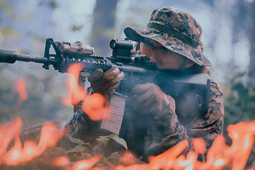 Image showing A soldier fights in a warforest area surrounded by fire