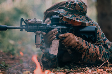 Image showing Modern warfare soldier surrounded by fire, fight in dense and dangerous forest areas