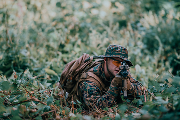 Image showing A soldier fights in a warforest area surrounded by fire