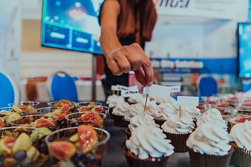 Image showing Business woman takes delicious food from the table while in the conference room