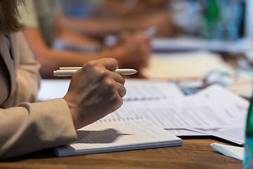 Image showing Closeup shot of business people hands using pen while taking notes on education training during business seminar at modern conference room