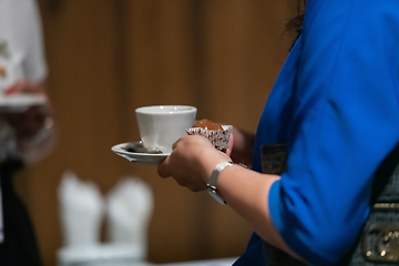 Image showing Close-up photo of a business woman holding a cup of fresh coffee