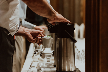 Image showing The waiter preparing coffee for hotel guests. Close up photo of service in modern hotels