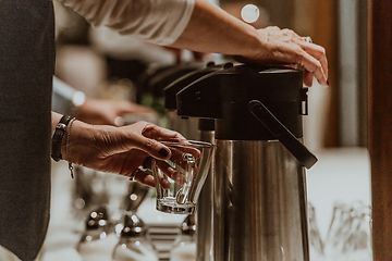 Image showing The waiter preparing coffee for hotel guests. Close up photo of service in modern hotels